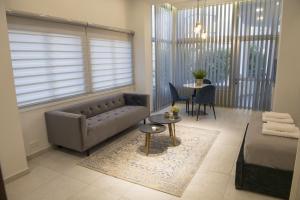 ニコシアにあるSTAY Glam Skin Studioのソファとテーブルのあるリビングルーム