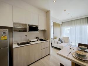 une cuisine et un salon avec un canapé et une table dans l'établissement 1 Bedroom Condo R272 Veranda Pattaya Beachfront, à Na Jomtien