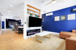 a living room with a couch and a tv on a wall at 2x Hottub, Pool, Minigolf, Theater,games, 20guests in San Antonio