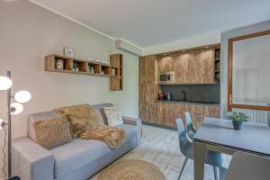 a living room with a couch and a table at Superior Village Apartments - Porto Letizia in Porlezza