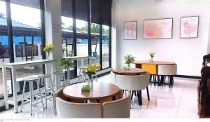 a restaurant with tables and chairs with flowers on them at T-NEE Hotel@Udon in Udon Thani