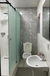 a bathroom with a toilet and a sink and a shower at NO 95 SUITES VI in Lagos +23 photos