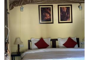 a bedroom with a bed with three pictures on the wall at Shikaar Valley in Khilchipur