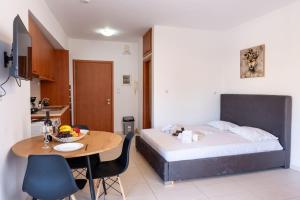 a bedroom with a bed and a table and a kitchen at Venetian Studio in the Centre 1 in Heraklio