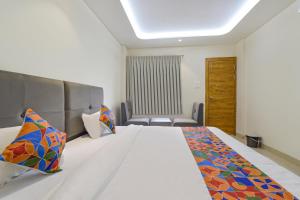 una habitación de hotel con una cama y una silla en FabHotel Synergy Stays, en Indore