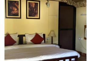a bedroom with a bed with red pillows at Shikaar Valley in Khilchipur +25 photos