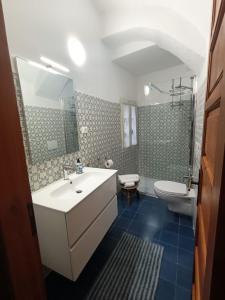 a bathroom with a white sink and a toilet at House of the Arches in Castelbianco