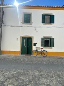 a bike parked in front of a building with a door at Casa de Alpalhão in Alpalhão