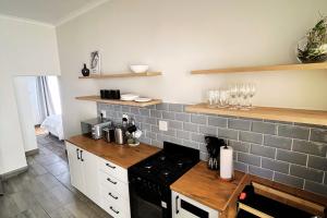 une cuisine avec une cuisinière et un comptoir dans l'établissement Luxury Vineyard Farmstay Flatlets, Somerset West, à Sir Lowry Pass