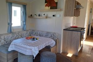 a room with a couch with a table and two stools at 3 Bedroom Caravan - Sleeps 8 Parking Pets Beach in Hastings +31 photos