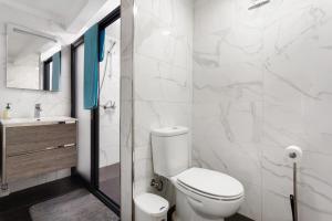 カニサルにあるStudio Home Away from Homeのトイレと洗面台を備えた白いバスルーム +14枚の写真