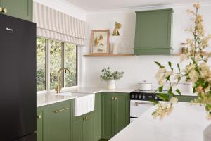 a kitchen with green cabinets and a sink at Oak Ridge Cottage in Maleny