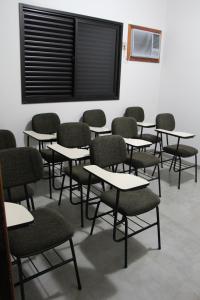 a group of tables and chairs in a room at Paradise Hotel in Campo Grande