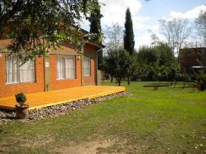 een houten terras aan de zijkant van een huis bij Las Casitas de Pepin in Santa Rosa de Calamuchita