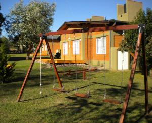 een schommel in een tuin voor een huis bij Las Casitas de Pepin in Santa Rosa de Calamuchita