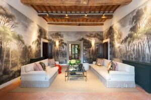 a living room with two couches and a wall mural at Fattoria di Vegi in Castellina in Chianti