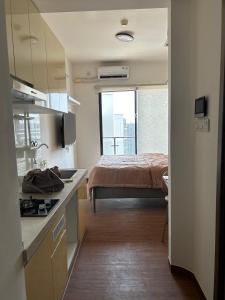 a kitchen and a bedroom with a bed in a room at Sky House Studio Apartment in CBD BSD near AEON and ICE in Cilenggang