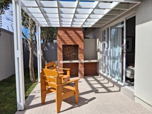 a patio with a bench and a fireplace at Arbre Stay at 1 ON YORK in George