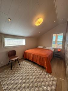 ein Schlafzimmer mit einem Bett und einem Stuhl und Fenstern in der Unterkunft Riihen Ullakko in Äkäslompolo