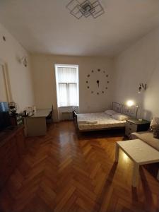 sala de estar con cama y reloj en la pared en CENTRAL Inn Zagreb, en Zagreb