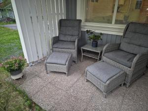 two chairs and a stool sitting on a porch at Rauhallinen rivitalo in Kilvakkala +4 photos