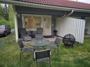a patio with a table and chairs and a grill at Rauhallinen rivitalo in Kilvakkala