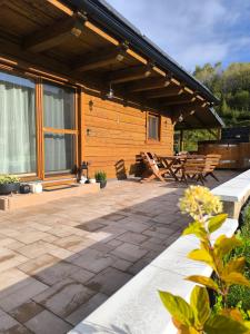 a house with a patio with a table and benches at Chata Starý Mlyn in Habovka