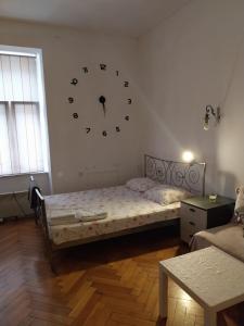 1 dormitorio con 1 cama con reloj grande en la pared en CENTRAL Inn Zagreb, en Zagreb