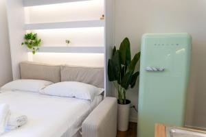 Habitación pequeña con sofá y nevera. en Vecchia Milano Luxury Suite, en Milán