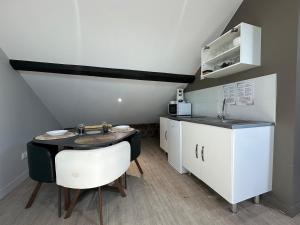 a small kitchen with a table and a sink at C Copenhague - charmant studio proche centre-ville in Charleville-Mézières