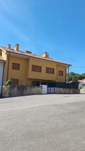 a yellow house with a driveway in front of it at Aldea Bricia 6 in Posada de Llanes