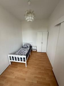Un dormitorio con una cama y una lámpara de araña. en Sanierte Unterkunft in Glauchau Nähe zu VW Werk, en Glauchau