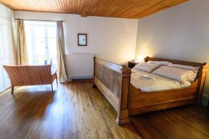 een slaapkamer met een bed, een stoel en een raam bij Les Jonquilles in Chef-Boutonne +11 foto's
