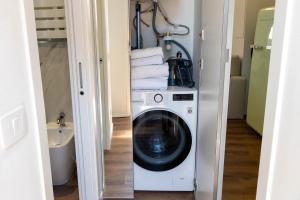 lavadero con lavadora y toallas en Vecchia Milano Luxury Suite, en Milán