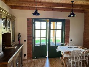 a kitchen with a green door and a table with chairs at Wiluki Nasz Dom in Wiluki