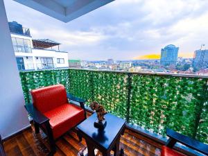 einen roten Stuhl und einen Tisch auf dem Balkon in der Unterkunft 3BD Apartment - Pool, Gym, Children Play Area in Nairobi