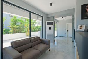 a living room with a couch and large windows at Q'in HOMES in Fethiye