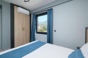 a bedroom with a bed and a large window at Q'in HOMES in Fethiye