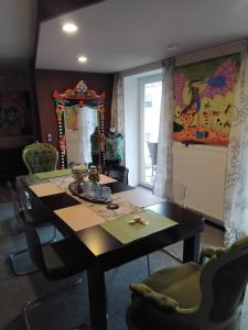 a dining room with a table and chairs and a mirror at Art Place Home in Rückersdorf +2 photos