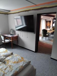 a bedroom with a bed and a tv and a desk at Art Place Home in Rückersdorf