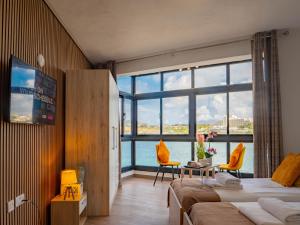 a hotel room with two beds and a large window at Shoreline Hideaway - Cross Over to the Beach! in St Paul's Bay