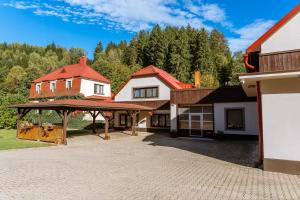 a house with a red roof and a driveway at Penzion U rybníka in Šumperk