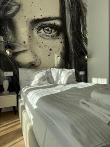 a mural of a woman with her eye on a bed at ROOSEVELTA RESIDENCE Apartments - przy OFF Piotrkowska in Łódź