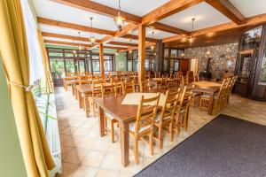 a dining room with wooden tables and chairs at Penzion U rybníka in Šumperk