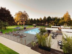 una vista aérea de una piscina con sillas y mesas en Novotel Nancy, en Nancy