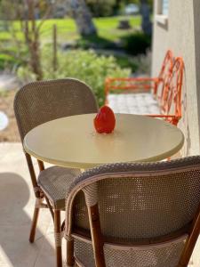 a tomato sitting on a table with two chairs at צימר על הנחל in Metsudat Menahem Ussishkin Alef