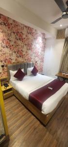 1 dormitorio con 1 cama grande y papel pintado con motivos florales en HOTEL IRIS inn, en Dombivli