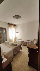 a hotel room with two beds and a desk at CasaAnna relax vicino al mare e al centro storico in San Felice Circeo