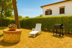 a bbq and a chair and a grill in a yard at Villa Carla accesso al mare privato posto auto riservato in Sperlonga