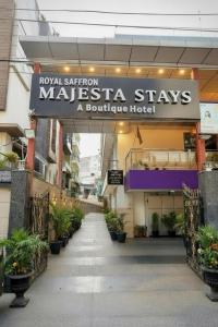 ニューデリーにあるMajesta Stay at Hotel Royal Saffron - Kirti Nagarの「メンズスタステイズ」と書かれた看板のある建物。ブティックホテル